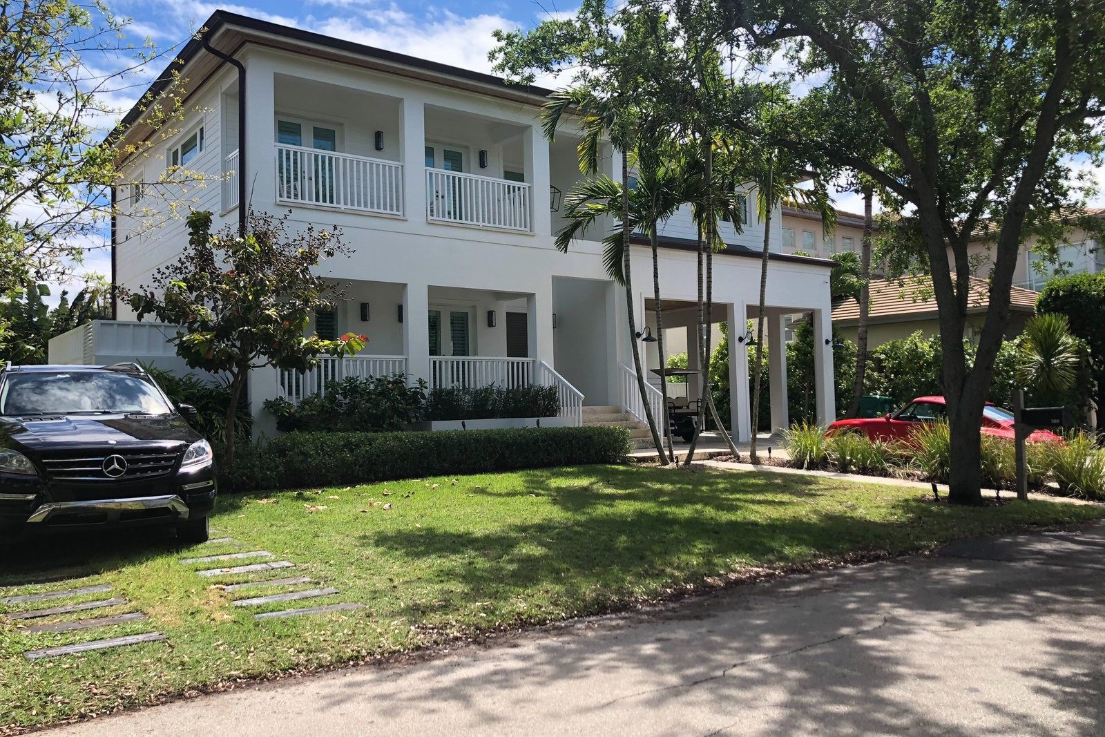 Two-story custom home with white balconies in Key Biscayne